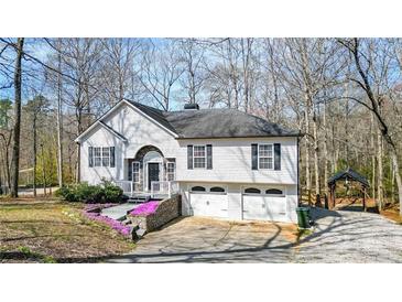 Charming home featuring a 2-car garage, stone accents, flowering plants, and lovely front yard at 416 Delane Dr, Dallas, GA 30157