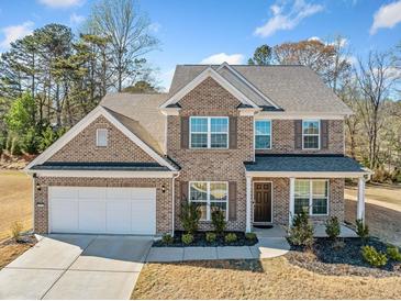 Beautiful two-story brick home with a covered front porch, well-maintained lawn, and attached two-car garage at 3505 Aqua Point Pl, Cumming, GA 30041