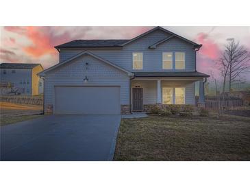 Charming two-story home featuring a covered porch, attached garage, and well-manicured lawn at 123 Ledgemont Way, Acworth, GA 30101