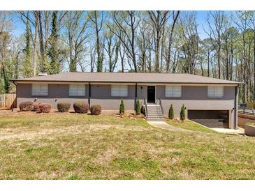 Ranch-style home featuring a brick facade, mature landscaping, and an attached garage in a suburban setting at 3819 Dora Se Dr, Smyrna, GA 30082