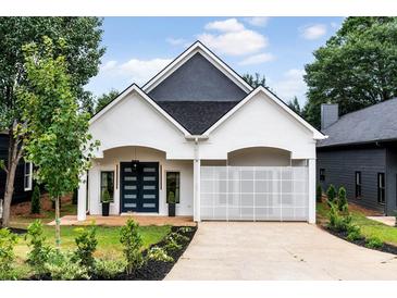 Charming home featuring modern design, a geometric accent wall, lush landscaping, and a welcoming driveway at 1035 Walker Se Ave, Atlanta, GA 30316