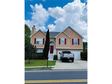 Inviting two-story home featuring a well-maintained yard, red shutters, and a two-car garage at 4528 Baker Grove Nw Rd, Acworth, GA 30101