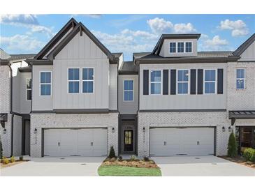 Beautiful townhome with light gray siding, brick accents, and a two-car garage at 2568 Silver Star Ne Dr, Marietta, GA 30066