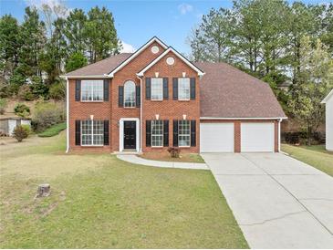 Charming two-story brick home with a well-manicured lawn and a two-car garage at 3920 Cain Mill Dr, Lithonia, GA 30038