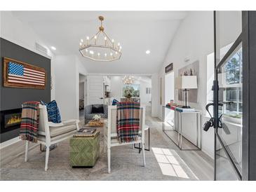 Bright living room featuring a modern chandelier, fireplace, and stylish decor at 6337 Lake View Dr, Buford, GA 30518