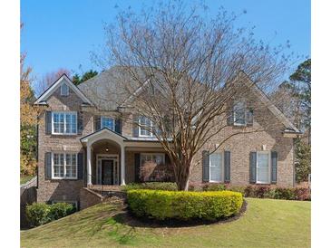 Traditional brick home with a covered front porch and manicured landscaping on a lush green lawn at 4126 Gold Mill Rdg, Canton, GA 30114