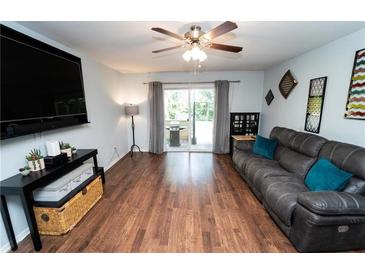 Bright living room featuring hardwood floors, a ceiling fan and sliding glass doors to the outside at 5400 Roswell Rd # K2, Atlanta, GA 30342