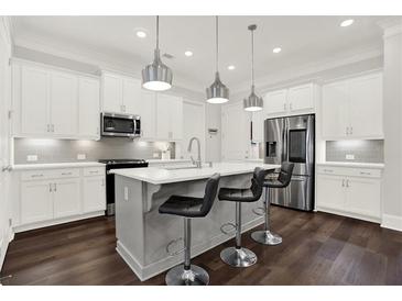 Modern kitchen features a center island with bar seating, stainless steel appliances, and ample cabinet space at 2128 Cosette Ln, Kennesaw, GA 30152