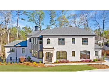 Stunning two-story home with white painted brick and black trim, professionally landscaped lawn at 835 Kenry Ct, Atlanta, GA 30342