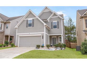 Charming home showcasing a well-manicured lawn, gray siding, and attached two-car garage at 3200 Baylor Cir, Mcdonough, GA 30253