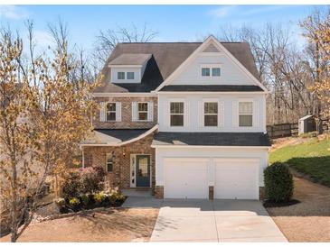 Charming two-story home with a two-car garage, brick and light blue siding and an inviting entrance at 4225 Hopewell Manor Dr, Cumming, GA 30028