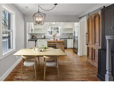 Bright dining area adjacent to a kitchen with white cabinets and stainless steel appliances at 2621 White Oak Dr, Decatur, GA 30032