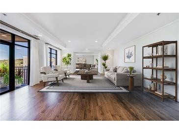 Bright living room with hardwood floors, large windows, and stylish decor with deck access at 3286 Northside Nw Pkwy # 1007, Atlanta, GA 30327
