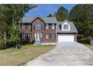 Charming two-story brick home with attached garage, a well-maintained lawn, and traditional architectural design at 3635 Spring Mesa Dr, Snellville, GA 30039