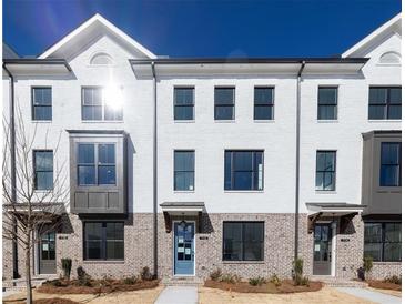 Charming townhome with a painted brick exterior and modern black windows, plus a beautiful blue front door at 1132 Larkin Dr # 34, Buford, GA 30518