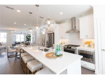 Modern, open-concept kitchen with stainless steel appliances, pendant lighting, and a large center island at 1132 Larkin Dr # 34, Buford, GA 30518