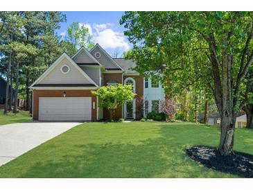 Charming two-story home with a brick facade, manicured lawn, and mature trees at 1725 Silverchase Sw Dr, Marietta, GA 30008