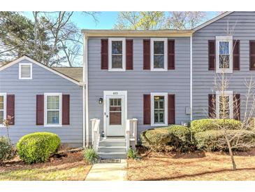 Charming townhouse exterior with gray siding and a cozy front entrance, complimented by lush green bushes at 403 Oak Harbor Ct, Marietta, GA 30066