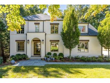 Stunning two-story home with a white brick facade, arched entry, and professionally landscaped front yard at 515 Danube Ne Rd, Atlanta, GA 30342