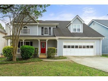 Charming two-story home with a well-manicured lawn and a bright red front door at 2802 Oak Meadow Ln, Snellville, GA 30078