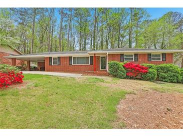 Charming brick home with a well-maintained lawn and vibrant red shrubbery at 1933 Silvastone Dr, Decatur, GA 30033
