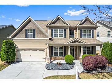 Charming two-story home featuring a manicured lawn, stone accents, and a welcoming front porch at 2195 Well Springs Dr, Buford, GA 30519