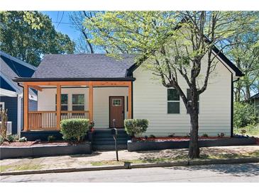 Charming home featuring a covered porch, complemented by manicured landscaping and a lovely tree at 514 English Nw Ave, Atlanta, GA 30318