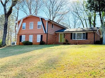 Charming two-story home with brick and siding exterior, complemented by a well-maintained front yard and mature trees at 2563 Hamill Dr, Buford, GA 30519