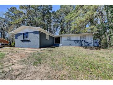 Charming single-story home with blue and white brick exterior surrounded by mature trees at 4756 Fellsridge Dr, Stone Mountain, GA 30083