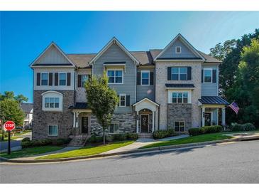 Charming townhome featuring stone accents, neutral colors, and a well-manicured lawn at 100 Marietta Walk Trce, Marietta, GA 30064