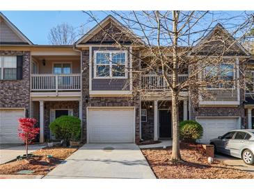 Charming two-story townhome with brick and siding exterior, attached garage, and well-maintained landscaping at 2359 Castle Keep Way, Atlanta, GA 30316