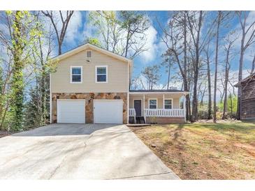 Charming home with stone accents, a covered porch, a two-car garage, and ample parking space at 5307 Mountain Village Ct, Stone Mountain, GA 30083