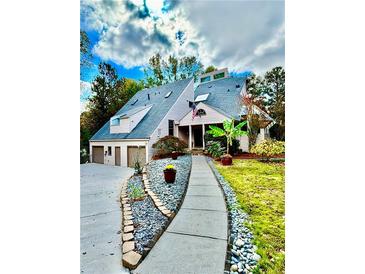 Beautiful exterior featuring a well-manicured lawn and a charming walkway leading to the front door at 3810 Galloway Dr, Roswell, GA 30075