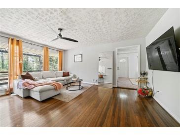 Inviting living room with hardwood floors, large windows, and a comfortable, neutral-toned sectional sofa at 1755 Fairburn Sw Rd, Atlanta, GA 30331