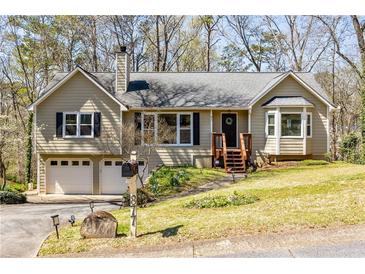 Charming split-level home featuring a two-car garage, inviting front porch, and manicured lawn at 877 Old Farm Walk, Marietta, GA 30066