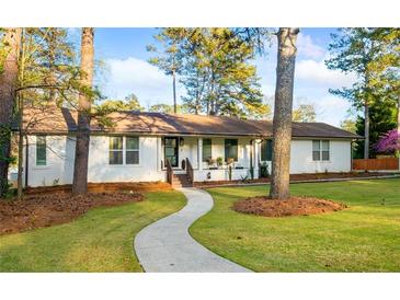 Charming white brick home features a well-manicured lawn and inviting walkway at 994 Redbud Sw Ln, Atlanta, GA 30311