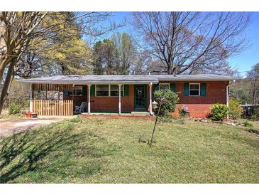 Charming single-story brick home with a covered porch and a well-maintained front yard at 1122 Byers Sw Dr, Marietta, GA 30060