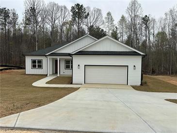 Charming single-story home featuring a white exterior, attached garage, and a well-manicured lawn at 135 Yancey Rd, Covington, GA 30014