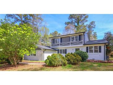 Charming white brick home with black shutters and well-maintained landscaping at 1749 Lauranceae Way, Riverdale, GA 30296