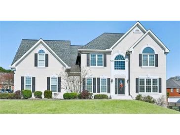 Beautiful home with a manicured lawn, symmetrical windows, and a welcoming front entrance at 2810 Burgundy Dr, Cumming, GA 30041
