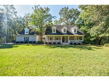 Charming single Gathering home with a covered front porch and a large manicured front lawn at 5440 Shady Grove Rd, Cumming, GA 30041