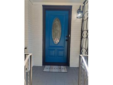 Charming blue front door with decorative glass and a 'Welcome' mat invites you into this lovely home at 1570 Childress Sw Dr, Atlanta, GA 30311