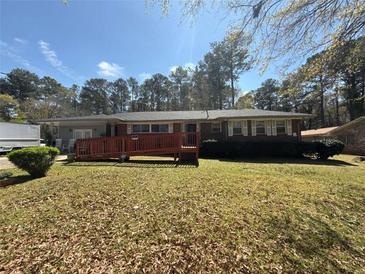 Charming single-story brick home featuring a wheelchair ramp and well-maintained front lawn with mature trees at 5169 Covington Hwy, Decatur, GA 30035