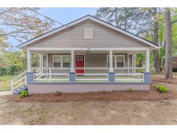 Charming single-story home with a cozy front porch and a red front door at 1248 W Ridge Ave, Stone Mountain, GA 30083