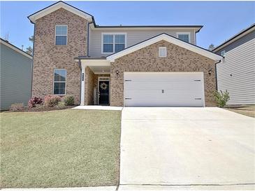 Beautiful two-story home featuring brick and neutral siding, manicured lawn, and attached two car garage at 516 Cunninghame Ct, Peachtree City, GA 30269