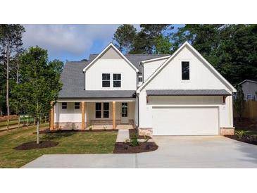 Charming two-story home features a covered porch, gabled roof and an attached garage at 1698 Cunningham Sw Rd, Marietta, GA 30008