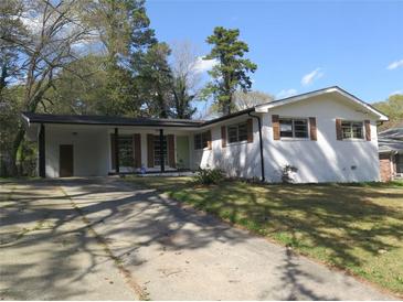 Charming single-story home with a white brick facade, brown shutters, and a spacious front yard at 3531 Creighton Sw Rd, Atlanta, GA 30331