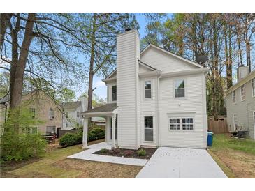 Charming two-story home with white siding, a brick chimney, and a well-manicured lawn in a suburban setting at 6446 E Windsor Ln, Norcross, GA 30093