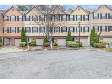 View of the townhomes showing multiple units with individual garages and neatly maintained landscaping at 1506 Knights Trl, Stone Mountain, GA 30083
