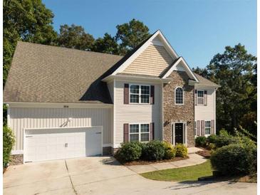 Charming two-story home featuring a stone facade, two-car garage, neutral siding, and a well-manicured front yard at 1814 Oak Branch Way, Loganville, GA 30052